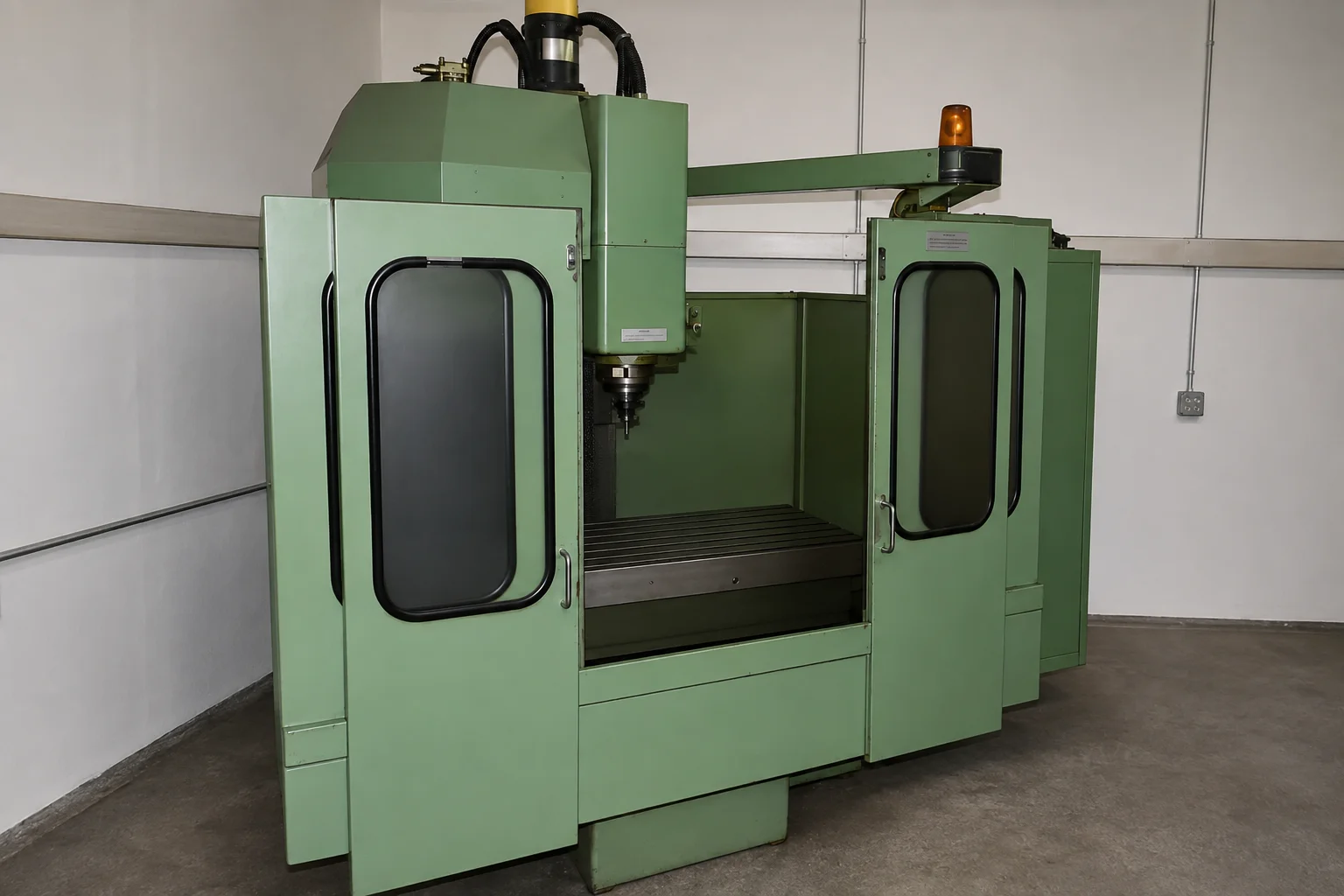 Fräsmaschine mit eingehaustem Arbeitsraum und senkrechter Frässpindel über dem Aufspanntisch