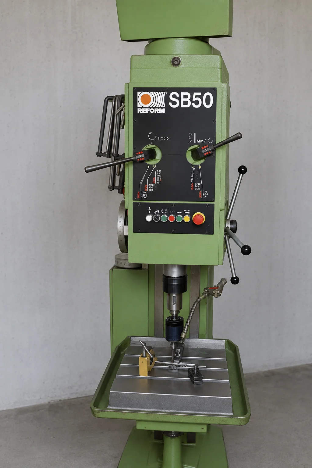 Bohrmaschine REFORM SB50 mit Bohrspindel über dem Arbeitstisch und aufgespanntem Werkstück